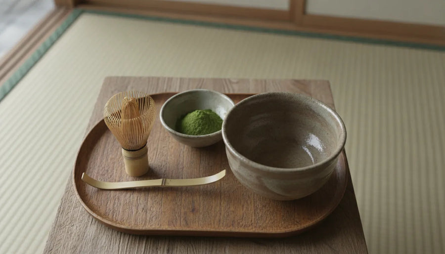 Handcrafted bamboo matcha whisk beside a bowl of matcha powder