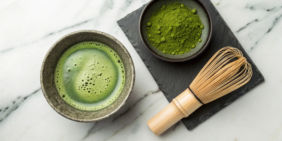 Ceremonial grade matcha in a bowl with a traditional bamboo whisk and powder.