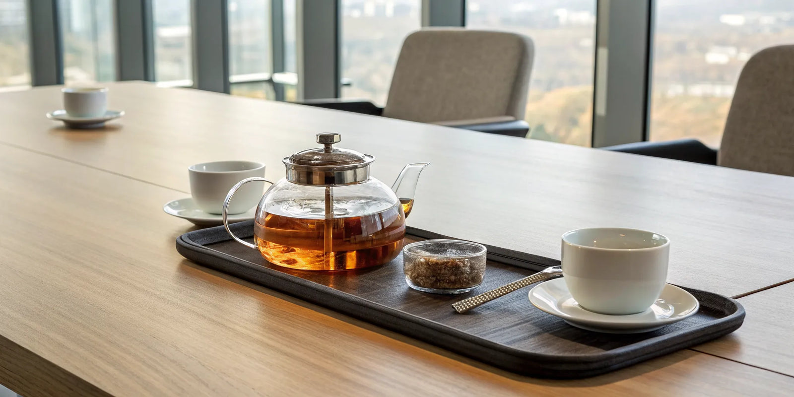 A modern tea time setup with a glass teapot and cups for a mindful ritual.